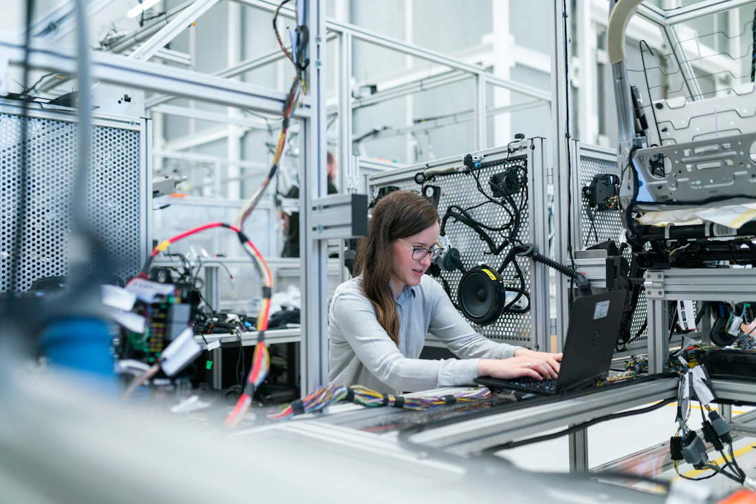 Engineer working beside factory machinery